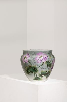 un vase orné de fleurs peintes, posé sur un socle blanc