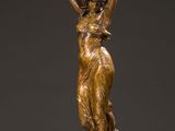 a bronze statue of a woman carrying a pot on her head