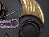 an assortment of leather and brass items on a black surface