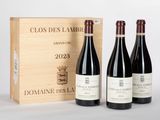 trois bouteilles de vin devant une caisse en bois