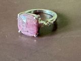 une bague sertie d'une pierre rose, posée sur une table