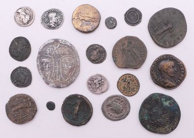 une image représentant une collection de pièces de monnaie romaines antiques posées sur une surface blanche