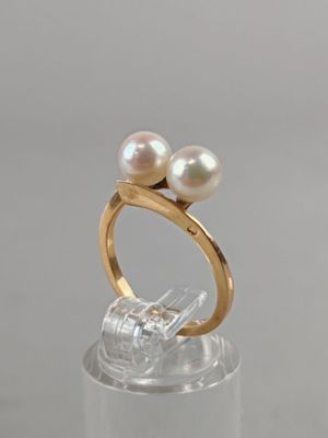 two pearl rings on top of a clear acrylic stand