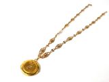 collier plaqué or avec un bouton doré et une chaîne dorée