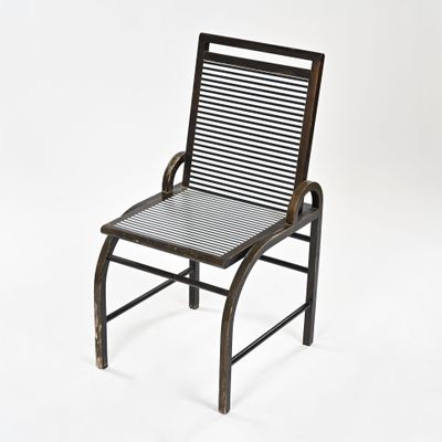 une image représentant une chaise en métal avec une assise rayée, sur fond blanc