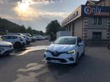 une voiture blanche garée devant un immeuble devant lequel sont garées d'autres voitures
