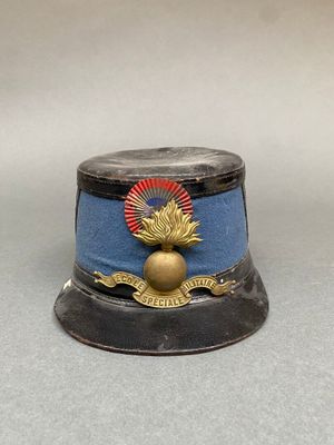 un petit chapeau bleu orné d'un emblème doré