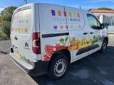 the van is parked on the side of the road with a lot of fruit on it