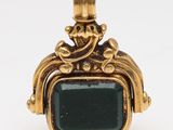 an image of a gold and green stone ring