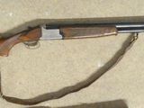 the rifle is laying on the floor next to a book