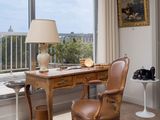 a desk with a chair and a lamp in a room