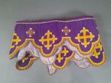 une image montrant un gros plan d'un tissu violet et jaune orné d'une croix