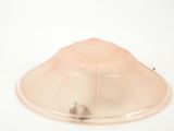 un dôme en plastique posé sur une surface blanche, surmonté d'une lampe