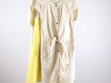 une robe jaune et blanche suspendue à un cintre dans une pièce blanche