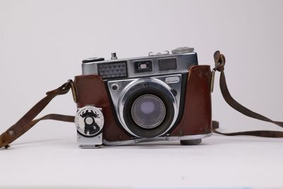 une courroie d'appareil photo en cuir marron à laquelle est accroché un appareil photo