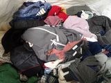 a pile of clothes that is on a bed