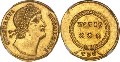 a gold coin with a woman ' s head and a wreath on it
