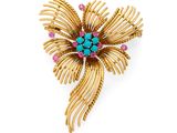 une image représentant une broche en or ornée de pierres turquoise et roses