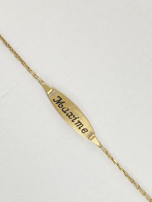 a close up of a gold bracelet with a name engraved on it