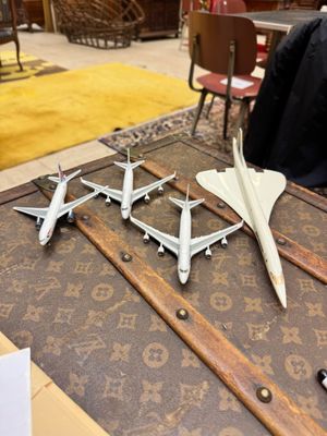 plusieurs maquettes d'avions posées sur une table en bois dans une pièce