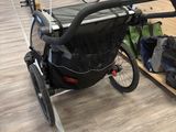 a stroller that is attached to the back of a bike