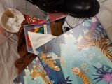 a pile of shoes and a book on a bed
