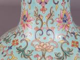 a blue vase with flowers on it sitting on a table