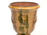 a gold vase with a face on it on a white background