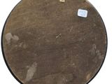 a brown drum on a white surface with a sticker on it