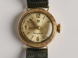 une image d'un gros plan d'une montre-bracelet sur une surface blanche