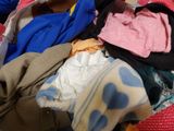 a pile of clothes that is on a bed