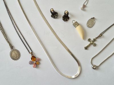 Lot de bijoux en métal argenté : chaines, médailles, pendent…