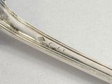 a silver spoon with a handle on a white surface