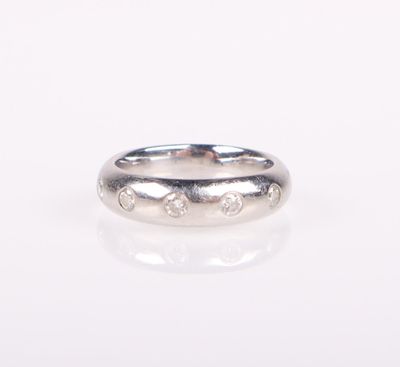 a close up of a silver ring with diamonds on a white surface