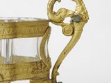 a gold plate with a glass on it on a white surface
