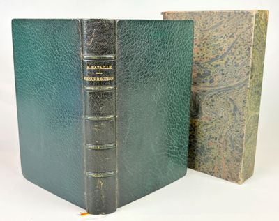 an old book sitting next to a closed book on a white surface