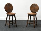 two wooden stools with turned legs and a circular back rest