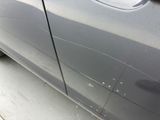 a close up of a car ' s side door with scratches on it