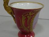 a red and gold vase with a bird on it
