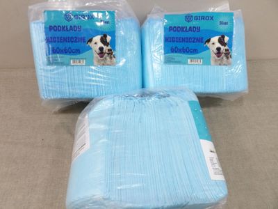 deux paquets de serviettes jetables bleues pour chiens posés sur une table