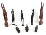 several wooden figurines of different shapes and sizes on a white surface