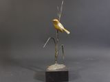 bronze sculpture of a bird perched on a branch on a marble base