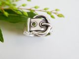 a close up of a silver ring with a face on it