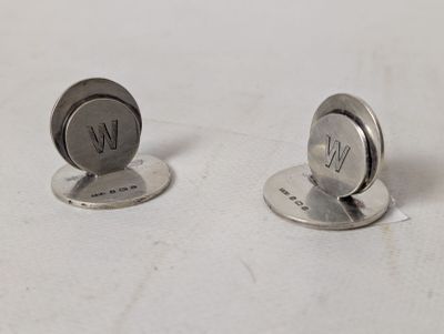 pair of silver plated cufflinks with initials on them on a white surface