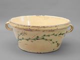 a small bowl with a handle on a gray surface