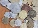 a pile of coins sitting on a wooden table