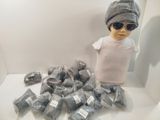 un mannequin portant un chapeau et des lunettes de soleil, à côté d'une pile de sacs en plastique