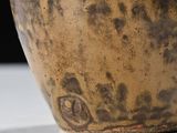 a close up of a brown vase on a white table