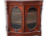 une photo d'une armoire en bois surmontée de deux miroirs