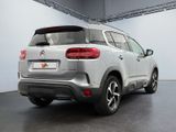 the rear end of a silver suv parked in a garage